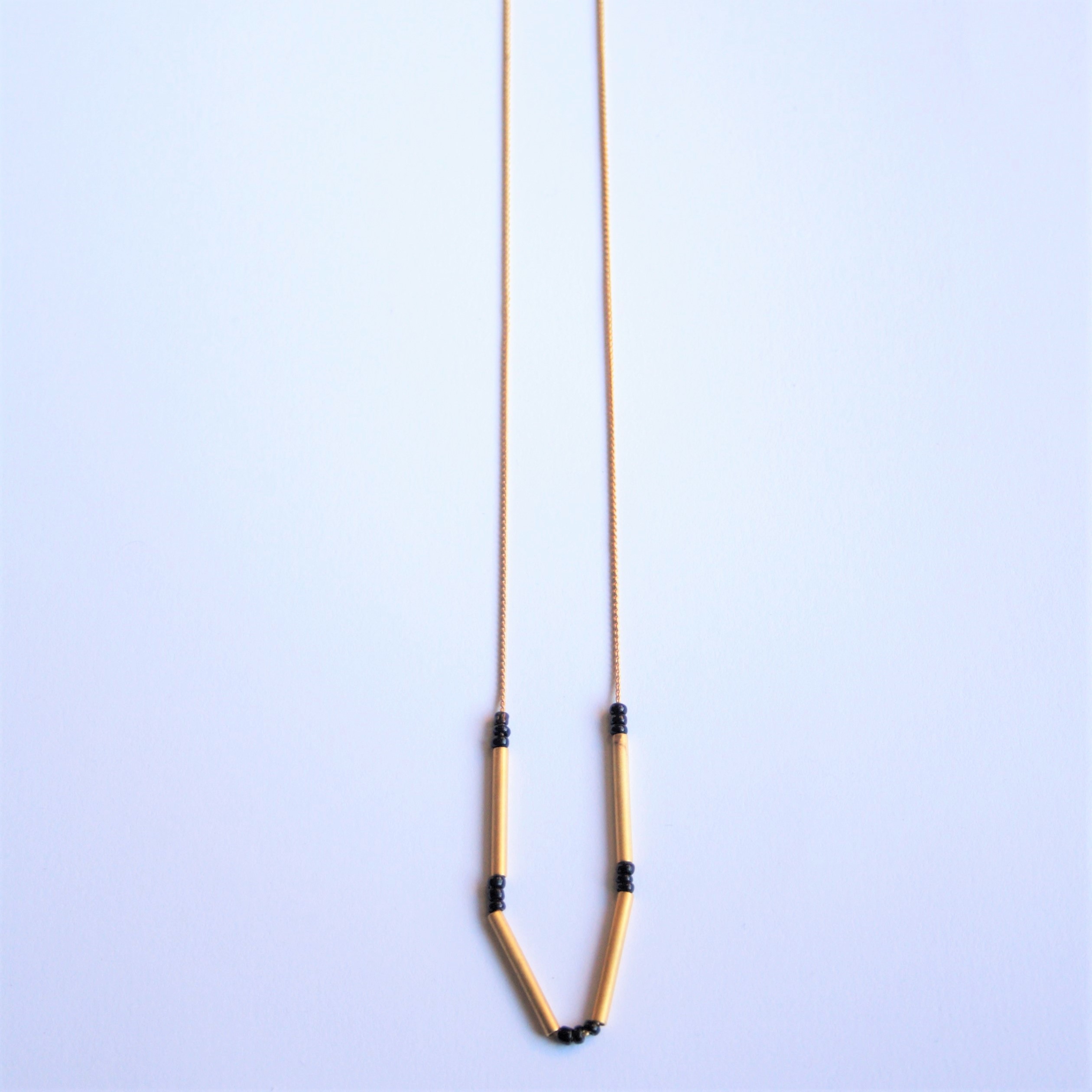 0026.2 Collar tubos dorado mate y granito negro mate